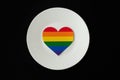 Rainbow heart on a white plate, black background