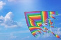 Rainbow kite flying in blue sky with clouds. Freedom and summer holiday Royalty Free Stock Photo