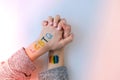 Rainbow LGBTQ flag painted on hand. Support for lgbt community. Honour of pride month. Connecting people, touching hands