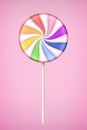 Rainbow Lolipop candy on pastel pink background.