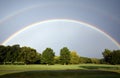 A rainbow with many shades of blue over a golf course