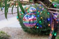 Rainbow-mirrored Disco Ball Ornaments Hanging from the Branches of an Oleander Tree which is also Adorned with a String of Royalty Free Stock Photo