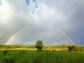 Rainbow in the morning with hill background sky green grass and village