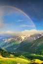 Rainbow in the mountain valley during rain Royalty Free Stock Photo