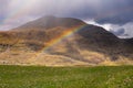 Rainbow in a mountains. Connemara, county Galway, Ireland. Green grass field in foreground, mountain in the background. Nobody. Royalty Free Stock Photo