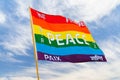 Rainbow multiolored peace flag wind flying against blue sky Royalty Free Stock Photo