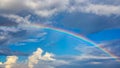 Rainbow over blue sky with clouds. Royalty Free Stock Photo