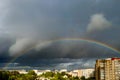 Rainbow over city. Atmospheric phenomenon in sky against background of thunderclouds. Royalty Free Stock Photo