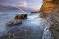 Rainbow over the cliff after passing an evening storm Royalty Free Stock Photo