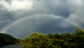 Rainbow over evergreen forests enclosing a beautiful Lake