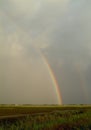 Rainbow over flat farmland Royalty Free Stock Photo