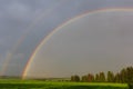 Rainbow over green field and forest Royalty Free Stock Photo