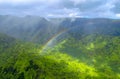Rainbow over green valley and mountains, aerial view from a helicopter at Na Pali Coast, Kauai, Hawaii Royalty Free Stock Photo