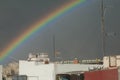 Rainbow over the houses of a city. Royalty Free Stock Photo