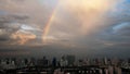 Rainbow over industrial buildings in city after rain. Bangkok city life