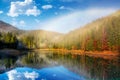 Rainbow over the lake in foggy spruce forest Royalty Free Stock Photo