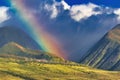 Rainbow over lush fields and mountains. Royalty Free Stock Photo