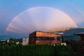 Rainbow over modern copper building in Austrian alp mountains village during sunset, Wildermieming, Mieminger Plateau, Tyrol,