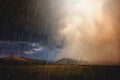 Rainbow over mountain landscape with heavy clouds