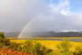 a rainbow is over an open meadow in Andenes, Andoya, Norway