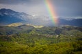 Rainbow over rolling hills with villages and forests in Transylvania, Romania, with the Bucegi mountains in the background Royalty Free Stock Photo