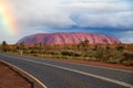 Rainbow over Uluru as storm passes over the desert scrub. Royalty Free Stock Photo