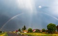 Rainbow over the village after rain in summer Royalty Free Stock Photo