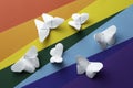 Rainbow paper background with white paper butterflies origami. Zero discrimination day concept