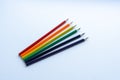 Set of six sharp rainbow-colored pencils except blue, from top view on a white background. Royalty Free Stock Photo