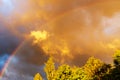 Rainbow after rain in a cloudy sky among dramatic clouds Royalty Free Stock Photo