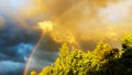 Rainbow after rain in a cloudy sky among dramatic clouds Royalty Free Stock Photo