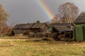 Rainbow after rain over the road and the old village. Royalty Free Stock Photo