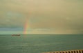 A rainbow after the rain and storms of the sea. Colorful types of clouds at sunrise, view of the sea horizon