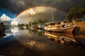 a rainbow reflected over a river, with boats in tow