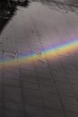 Rainbow reflected on a wet urban floor