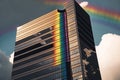 rainbow reflected in the windows of a towering skyscraper
