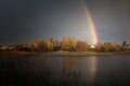 Rainbow with reflection in the lake and the village house Royalty Free Stock Photo