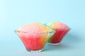 Rainbow shaving ice in glass dessert bowls on blue background Royalty Free Stock Photo