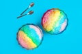 Rainbow shaving ice in glass dessert bowls and spoons on light blue background, flat lay Royalty Free Stock Photo