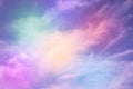 Rainbow sky with fluffy clouds. Abstract purple green yellow background with space for design. Multicolored toned sky.