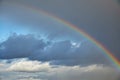 Rainbow in the sky after the rain. Evening sky. White clouds. You can see the sky through the storm clouds. High in the Royalty Free Stock Photo