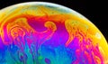 Rainbow soap bubble on a dark background. Close-up of colorful surface