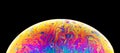 Rainbow soap bubble on a dark background. Close-up of colorful surface