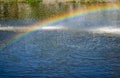 Rainbow spray fountain on the background of the river Royalty Free Stock Photo