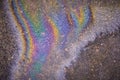 rainbow stripes on wet asphalt after fuel spill from car. Royalty Free Stock Photo