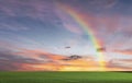 Rainbow sunset on blue sky fluffy white clouds summer   at sea  meadow green grass field nature background landscape Royalty Free Stock Photo