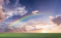 Rainbow sunset on blue sky fluffy white clouds summer   at sea  meadow green grass field nature background landscape Royalty Free Stock Photo