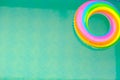 Rainbow swim ring in the pool.Summer time. Swimming ring in the pool in water on a sunny summer day . Bathing season Royalty Free Stock Photo