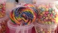 Rainbow swirl lollipop on a food cart.