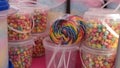 Rainbow swirl lollipop on a food cart.
